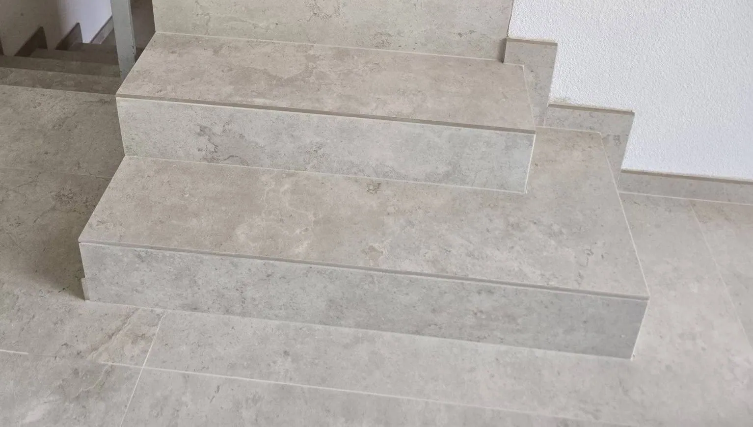 Après : l'escalier recouvert de dalles grand format claires, sans cornière