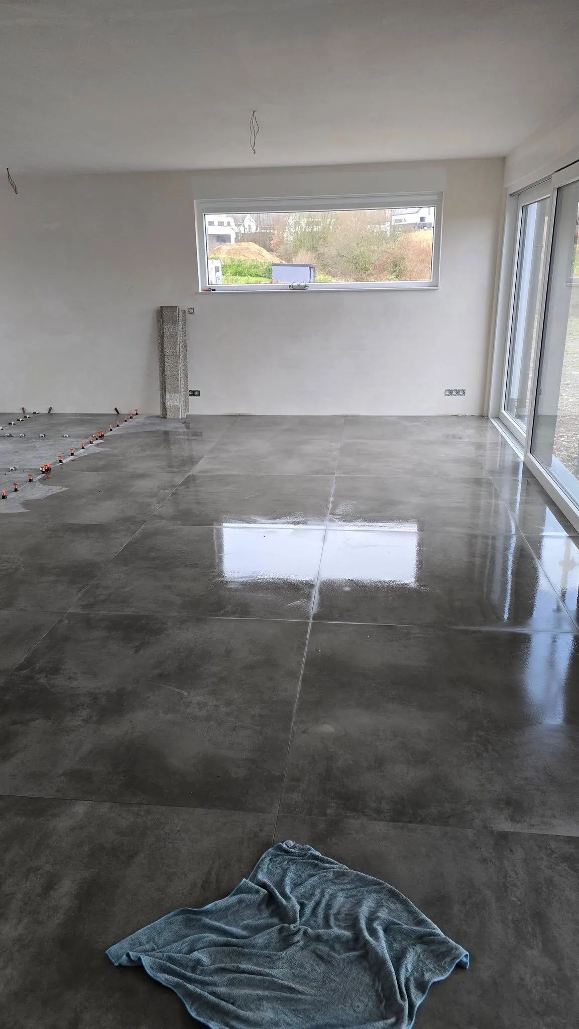 Sol de séjour en grandes dalles effet béton poli, baies vitrées